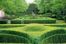 Eindrucksvolle Gartenanlage mit formgeschnittenen Hecken und gestalteten Wegen, ein Beispiel für Gartenarchitektur.