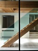View through window of wooden staircase in contemporary foyer