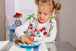 Little girl putting cress seeds on a cotton pad