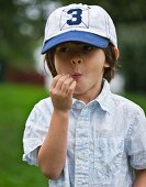 A little boy in a cap chewing