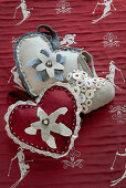 Heart-shaped, decorated felt cushions on red cloth with skier motif