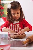 Little girl kneading gingerbread dough