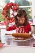 Little girl rolling out gingerbread dough