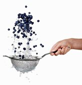 Blueberries being washed in a sieve