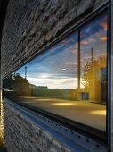 Horizontales schmales Fenster in Natursteinfassade