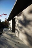 Dappled light on white facade of modern house