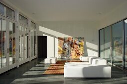 Weisses Polstersofa im minimalistischen Wohnraum mit Glasfassade
