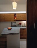 View into open-plan designer kitchen with concrete work surface on counter