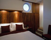 Bedroom with partially wood-panelled walls and open doorway