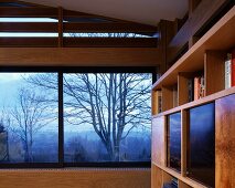 Detail of room with panoramic window and view of autumnal landscape