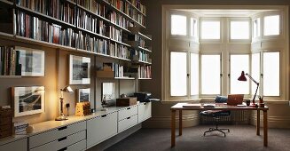 Modern library with desk in front of traditional bay window