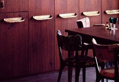 Tisch und Stühle vor Einbauschrank aus Holz