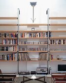 Half-visible coffee table with glass top in front of modern bookcase