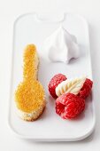 A spoon-shaped sponge cake with raspberries and cream
