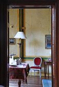 View into room with table and red chair