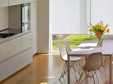 White dining table with shell chairs in modern kitchen