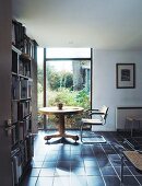 Round table and chair in study with bookcase