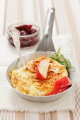 Baked camembert with an almond crust and apples served with cranberry jelly