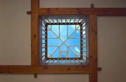 View of sky and light from above through tent-shaped skylight and ceiling aperture surrounded by balustrade