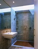 Designerbad mit Oberlicht über bodengleicher Dusche mit Holzrost und grossformatigen Fliesen