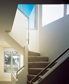 Spiral staircase with stair carpet and stainless steel handrails