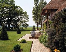 Landhaus mit Terrasse und gepflegtem, offenem Garten mit englischem Rasen