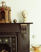 Detail of antique, dark wood mantelpiece with bust