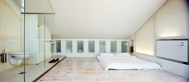 Minimalist bedroom with glazed ensuite bathroom in attic