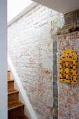 Yellow painted wall cabinet on brick wall of stairwell