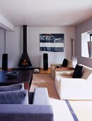 Eleganter Designer-Wohnraum mit hellen Sitzmöbeln vor offenem Kaminofen