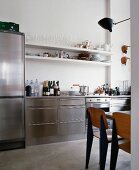Fifties-style wooden chairs in stainless steel kitchen