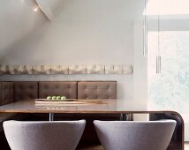 Dining table with upholstered, designer chairs in corner of room