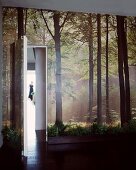 Fototapete mit Waldmotiv an Wand und offenstehende Tür