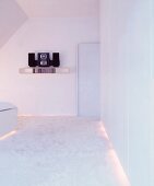 White bedroom with flokati carpet and indirect lighting under furniture