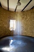 Duschen in alten Gemäuern mit geschwungener Natursteinwand in grosszügigem Duschbereich