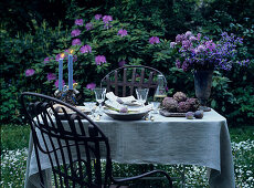 Table in garden set in romantic style with candles and flowers