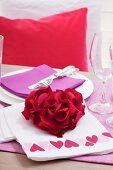 Festive place setting with rose petals arranged in heart