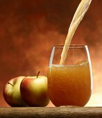 Pouring 'naturally cloudy' apple juice into a glass