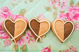 Three heart-shaped vanilla-chocolate cookies next to one another