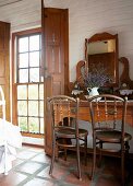 Antique dressing table and wooden chairs in a rustic bedroom