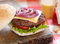 Cheeseburger on rustic chopping board