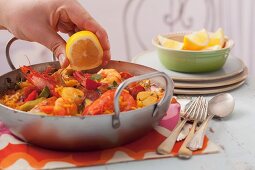 Drizzle paella with lemon juice