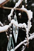 Glass Christmas decorations hanging from twig