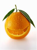 Eine Orange mit Blättern und herausgeschnittenem Schnitz