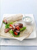 Spicy beef wraps with tomato and hummus