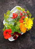 Brightly coloured, cottage-garden flowers in white dish