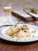 Poached chicken breast with cream sauce and herbs