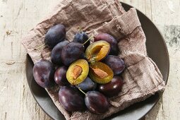 Fresh plums, whole and halved