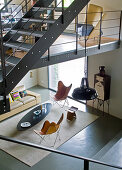 Blick von Galerie in minimalistischen Wohnraum auf Klassiker Sesseln und Couchtisch