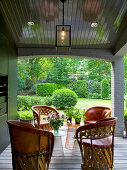 Roofed terrace with Mexican wood and leather chairs and small, designer side tables